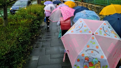 雨の日、下校中の小学生